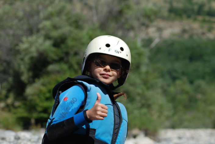 Une fillette montre qu'elle est contente de participer aux activités de La Vague Rafting